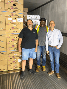 team members with boxed produce in refrigerated truck